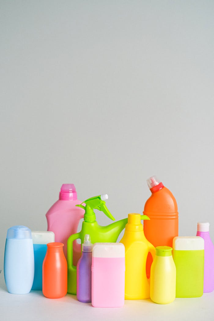 creative-03 Assorted colorful plastic cleaning bottles on a white background.