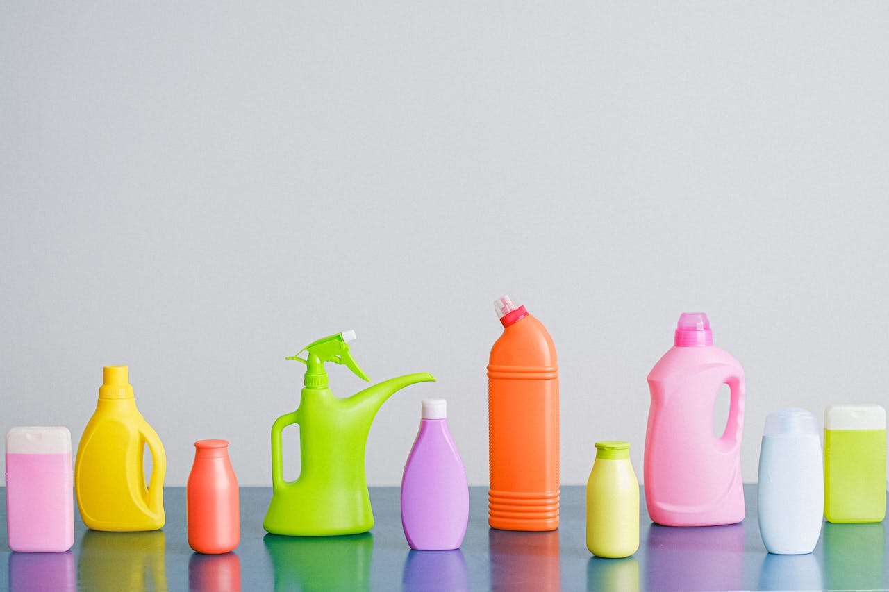 mobile-02 A vibrant assortment of cleaning product containers arranged on a reflective surface, perfect for household sanitation themes.